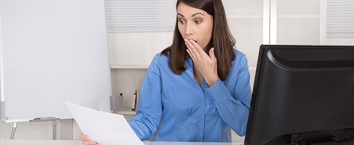 730x300 erschrockene Frau am Schreibtisch mit Schreiben