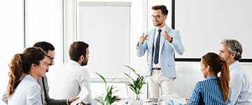 360x150 - gestikulierender Mann vor Leinwand mit Gruppe