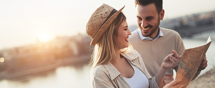 730x300 - Frau zeigt auf Landkarte, sie und Mann lachen