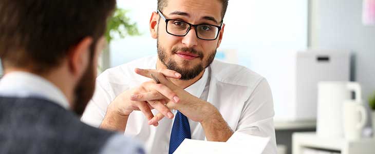 730x300 Mann mit verkreuzten H&auml;nden zuh&ouml;rend