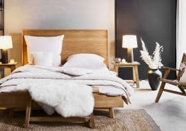 Symetria tworzy spójne i bardziej uporządkowane wnętrze. Jeśli takie właśnie lubisz, ustaw dwie identyczne lampy po obu stronach łóżka.