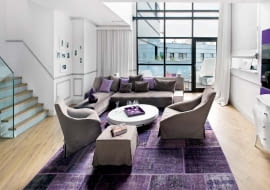 Wytrawne kolory, gzymsy na ścianach i lekkie lniane zasłony dodają wnętrzu paryskiego szyku. Sofa Night&Day, proj. Patricia Urquiola, fotele Doda, proj. Ferruccio Lavani Motleni, dywan Mystic Kymo