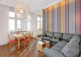 Kasia i Marek nie wyobrażali sobie życia poza Podgórzem - nadwiślańską dzielnicą Krakowa, ze specyficznym klimatem. Nie zniechęciło ich nawet to, że znalezione przez nich mieszkanie w starej kamienicy nadawało się do generalnego remontu, a układ pomieszczeń przypominał labirynt. <BR /> MIESZKANIE. W pokoju dziennym najmocniejszym akcentem kolorystycznym jest pasiasta tapeta położona na jednej ścianie. Wielobarwną okładzinę rozświetlają lampki LED zainstalowane za szeroką listwą sztukateryjną (za takimi listwami ukryto również okienne karnisze). Przy  rozłożystej kanapie narożnej stoi stolik kawowy Bloc zaprojektowany przez Piotra Kuchcińskiego.