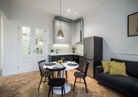 Ozdobami salonu są krzesła w stylu vintage i wisząca pozłacana lampa