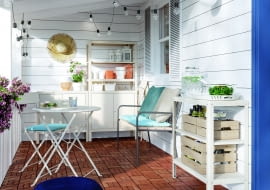 Drewniane skrzynki, dużo kwiatów i doniczki, a nawet słomiany kapelusz jako element dekoracji tworzą sielski klimat.