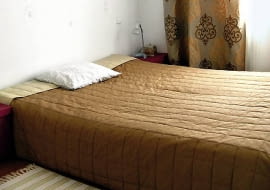 PRZED ZMIANĄ. Do niewielkiej sypialni właścicielka wstawiła jedynie łóżko. Przykryła je pikowaną narzutą w tabaczkowym kolorze. Z tkaniny o takim samym odcieniu uszyła zasłony.