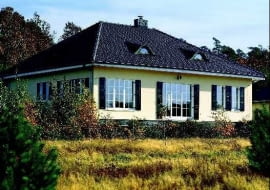 Domostwo na planie prostokąta nakryte czterospadowym dachem - zwarta bryła i dodatkowo okiennice ograniczają straty ciepła i ułatwiają ogrzewanie budynku. Poddasze zwiększa powierzchnię domu, ale skosy zmniejszają komfort życia na poddaszu