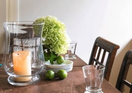 Szklane lampiony na świece to jedna z najmodniejszych dekoracji salonów. Moda na nie przybyła do nas ze Stanów Zjednoczonych. W takiej aranżacji świece dodatkowo zyskują na elegancji, a nasz stół jest lepiej chroniony przed woskiem.