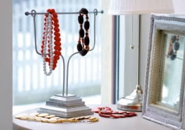 Co ma wisieć jest oczywiście ważne. Nie mniej istotne jest również - na czym. Okazuje się, że nawet tak prozaiczne drobiazgi jak wieszaki mogą być ciekawą ozdobą. Nasza stylistka wykorzystała do ich zrobienia dość nietypowe materiały. <BR />Skarbczyk - drewnianą podstawkę (tu wykorzystano tralkę - element balustrady przy schodach) malujemy na srebrny kolor. W niej osadzamy dwa wygięte aluminiowe pręty z 'pętelkami' na końcach, przez które przekładamy rurkę z przyklejonymi metalowymi koralikami.