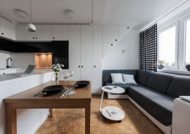 Biały, satynowy ciąg zabudów sięga aż lukarny, nad którą wykonano skosy nawiązujące do istniejącego poddasza. W ten sposób powstała symetria, która wprowadziła w przestrzeni dziennej równowagę.