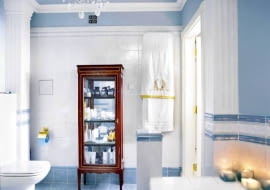 Meble łazienkowe są stylizowane na klasycystyczne z początku XIX wieku. Do tego stylu nawiązuje również żyrandol. Nawet wzory na ręczniku do złudzenia przypominają te sprzed dwustu lat.