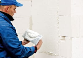 Ściany domu dobrze jest tynkować w kilka miesięcy po jego wymurowaniu, tak żeby budynek zdążył osiąść