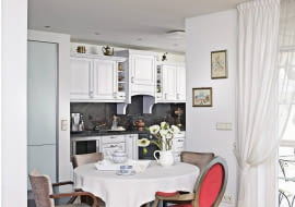 Część kuchenną wyznacza odmienny kolor podłogi i mebli. W kuchni prawie nie ma brązów i beżów dominujących w kącie jadalnym. Zamiłowanie właścicielki do kontrastowego łączenia stylów i barw widać nawet w doborze krzeseł, pochodzących z różnych kompletów.