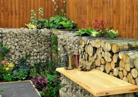Drewno w ogrodzie. Pociętymi pniakami można wypełnić gabiony - modne ostatnio konstrukcje ze stalowej siatki