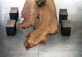 NUMER JEDEN. Blat tego niezwykłego stołu został zrobiony z ogromnego pnia kauri, najstarszego i najdroższego drewna na świecie, pochodzącego z Nowej Zelandii. Taki luksusowy mebel nie potrzebuje towarzystwa. Właściwie powinien stać samotnie w pustej przestrzeni, bo swoją urodą przyćmi wszystko. riva1920.it