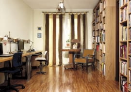 Dekoracja okna to jeden z elementów ocieplających to pomieszczenie. Dzięki lekko prześwitującym zasłonom do wnętrza wpada dzienne światło, ale słońce nie odbija się w monitorach. Na podłodze efektownie prezentuje się parkiet przemysłowy.