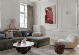 W salonie zieleń sofy harmonizuje z różem abstrakcyjnego obrazu Aleksandry Szewczuk, który wkomponowano w stylizowaną sztukaterię.