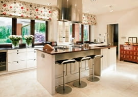 <B>Wyspa, czyli wolno stojąca niska zabudowa, niepołączona z głównym ciągiem roboczym, pełni kilka funkcji: uzupełnia główną zabudowę o dodatkowe schowki i blat roboczy, skraca dystans między urządzeniami AGD, a w kuchni otwartej na salon wydziela optycznie strefy o różnym przeznaczeniu.</B> <BR >KUCHNIA - BEZ TAJEMNIC. Gotowanie nie jest już czynnością, z którą trzeba się ukrywać. Teraz stało się swoistym reality show z udziałem nie tylko domowników, ale nierzadko także gości. Rangę tego wydarzenia podkreśla miejsce akcji - wyspa na środku pomieszczenia. <BR >W przestronnej kuchni (ok. 24 m kw.) zaprojektowano wyspę o wymiarach 280 x 110 cm. Po jej obu stronach pozostało jeszcze szerokie przejście (ponad metr). Kuchnia jest częściowo otwarta na salon, a przed rozchodzeniem się zapachów z gotujących się potraw chroni zawieszony nad płytami grzejnymi okap o dużej wydajności. Umieszczone w nim lampki są dodatkowym oświetleniem blatu. Główne to reflektorki o regulowanym kącie padania światła, zainstalowane w suficie. Wnęka pod blatem gł. 35 cm wystarcza, by osoby siedzące na stołkach barowych mogły wygodnie ułożyć nogi.