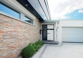 Wybierając skrzydła w jasnych kolorach, możemy optycznie 'schować' wejście do domu. Na zdjęciu: drzwi aluminiowe AT400, Ud = 0,75 W/m?K, wielopunktowe ryglowanie, ciepły próg, klasa RC2, cena 17 649 zł (netto), INTERNORM