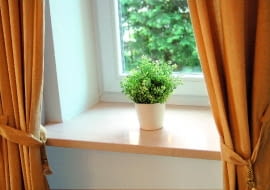 Marmurowy parapet o prostej formie zamontowany we wnęce okiennej