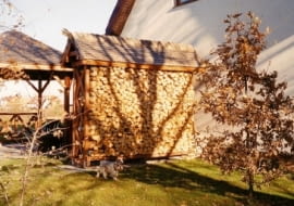 Mały skład na drewno wykorzystany jako parawan. Osłania letni taras i wnętrze ogrodu od strony dodatkowej bramy wjazdowej, stanowiącej 'wyłom' w żywopłocie.