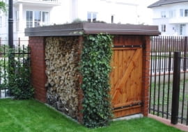 Dwa w jednym: składzik gospodarczy z miejscem na drewno do kominka oraz śmietnik dostępny od strony ulicy.