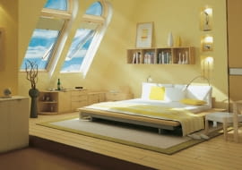 Sypialnia w otwartej przestrzeni na poddaszu. Duże okna połaciowe doświetlają pomieszczenie, a nocą umożliwiają oglądanie nieba