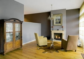 ARANŻACJE. Czy przestronność salonu albo sypialni może być wadą? Tylko wówczas, gdy we wnętrzu panuje bezosobowy, chłodny klimat. Taki problem pomoże rozwiązać przemyślana aranżacja oraz - co równie ważne - odpowiednia, wprowadzająca miły nastrój kolorystyka.<br/> Kąt wypoczynkowy z dwoma fotelami zwróconymi w stronę kominka, wydzielony niską ścianką z dużej przestrzeni dziennej, zyskał na przytulności. Do jego aranżacji użyto barw neutralnych - beżów, brązów i szarości. Spokojna kolorystyka sprzyjająca relaksowi nie wydaje się nazbyt monotonna, co jest zasługą zastosowania kilku harmonizujących ze sobą odcieni.