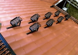 Stopnie kominiarskie umieszczone gęsto na dachu. Zapewniają bezpieczne dojście od okapu do widocznej w lewym rogu zdjęcia ławy kominiarskiej.