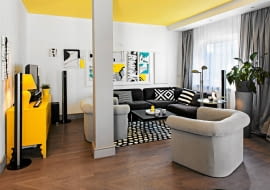 <B>W mieszkaniu młodych projektantów Zuzanny i Eryka w oczy rzucają się cztery kolory. Czwarty to jaskrawy żółty, któremu towarzyszy biel, czerń i szarość. I właśnie żółty miał w koncepcji wystroju grać pierwsze skrzypce. I tak się stało, gdy na tę barwę pomalowano sufity.</B> <BR />Aby powiększyć strefę dzienną, wyburzono ściany - pozostał po nich słup konstrukcyjny. Pomalowano go na szaro, by jak najmniej rzucał się w oczy. Barwa ta nawiązuje do koloru zasłon. Ścianę za narożnikiem zdobią obrazy pani domu Zuzanny Lesińskiej.