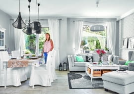 OD RAZU JAŚNIEJ. Ciemny stary kredens od teściów właścicielka przemalowała na biało. Do niego dobrała stół i krzesła z IKEA w tym samym kolorze, a całość przełamała czarnymi lampami ze sklepu Nowodvorski Lighting. Kanapa jest z MTI Furninova, dywan - z IKEA, żyrandol - również z firmy Nowodvorski Lighting. Podłoga to płytki ceramiczne imitujące drewno (marki Imola); gospodyni sama zadecydowała, jak mają być ułożone.