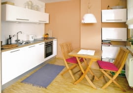 <B>Upiększyć, zmienić, udoskonalić... Właścicielka tej otwartej na salon kuchni cały czas zastanawiała się, co jeszcze można w niej zrobić, żeby było ładniej i wygodniej. To dążenie do perfekcjonizmu zaowocowało wnętrzem nowoczesnym i praktycznym. Zaaranżowano je minimalistycznie, a zarazem dekoracyjnie, co rzadko idzie w parze. Wprowadzono niewiele zmian funkcjonalnych (przede wszystkim nowy, wygodniejszy kącik jadalny), za to sporo estetycznych, które dodały wnętrzu indywidualnego charakteru. Warto zwrócić uwagę na ścianę nad ciągiem roboczym, którą oryginalnie ozdobiono przepisami na ulubione potrawy gospodyni.</B> <BR />TAK BYŁO. Wygodna, oszczędnie umeblowana kuchnia już się właścicielce znudziła. Szczególnie opatrzyła się jej kolorystyka, chciała też inaczej zaaranżować kącik jadalny. Miał być nie tylko praktyczny, ale i efektowny, bo właśnie w kuchni najczęściej przebywają goście.