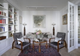 DESIGNERSKIE fotele Thoneta, autentyczne lampy stojące i stolik z lat 20 ubiegłego wieku. oraz zabytkowy dywan zostały wyszukane przez gospodarzy i przyjaciółkę pani domu – Annę Bimer na Warszawskich Targach Antyków w Broniszach. Kolorystykę odnowionej tapicerki foteli, współczesnej kanapy, a nawet zdobiących ją poduszek (ze sklepu sweetliving.pl oraz marki Maja Laptos) dopasowano do palety barw głównego obrazu, zdobiącego ścianę nad sofą. To grafika wspomnianej artystki Anny Bimer.