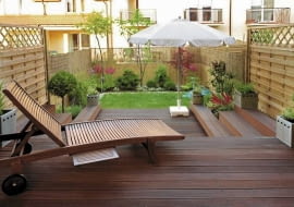 Aranżacje ogrodów. Mały ogród w stylu orientalnym. Rozłożony drewniany leżak zaprasza amatorów słodkiego lenistwa