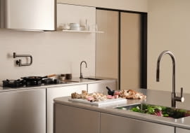 Idealna do nowoczesnej architektury kuchennej ze stali nierdzewnej: Tara Ultra w kolorze Dark Chrome jako jednouchwytowa bateria z funkcją wyciągania, jako dystrybutor ciepłej i zimnej wody oraz jako napełniacz garnków.