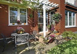 Aranżacje ogrodów. Mały ogród w kwiatach. Na ścianach, stoliku, schodkach - miejsce dla kwiatów znajdzie się wszędzie