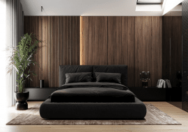 Sypialnia z ciemną, fornirowaną płytą na ścianie w asyście grafitowego łóżka, z grafitową pościelą to kwintesencja nowoczesnej elegancji. Projekt wnętrza Naboo Studio.