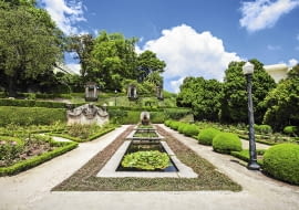 Prostokątne oczka wodne (w tym samym ogrodzie) porastają różowe i białe grzybienie.