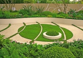 Pomiędzy betonowymi kostkami 'namalowano' zielone pasy z trawy. Natomiast na murawie - białe łuki z kostki. Przy takim rozwiązaniu trzeba wybrać nasiona traw odpornych na deptanie, a skrawki murawy - regularnie podlewać i kosić.