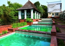 Kaskada wodna , a ltana i zegar słoneczny na ścianie budynku, z mottem Wincentego Kadłubka: "Lepiej stracić rzeczy niż czas".