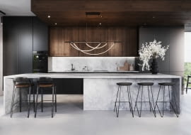 Przedłużony blat tworzy wygodny stół, który zamiast na tradycyjnych nogach stoi na płycie, takiej samej jak reszta zabudowy, dzięki czemu całość jest spójna. juan.pl