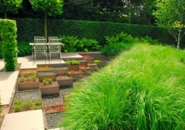 Sprytne rozwiązanie - ogród z 'samoobsługowych' sukulentów w aluminiowych skrzyniach i gigantyczej rabaty z trwałych ozdobnych traw.