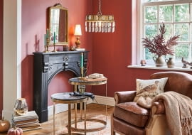 Dekoracyjne oświetlenie, ciepły pled, dodatki w ciepłych barwach – wszystko to wprowadza jesienny klimat do salonu.