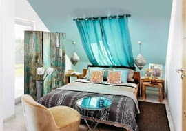 STYL ORIENTALNY. Ta sypialnia z prostymi drewnianymi meblami odnalazłaby się w wielu stylach. Jednak dodatki - tkaniny dekoracyjne, lampy z kutego metalu oraz akcenty żywych, niemal świecących kolorów - dodają jej orientalnego klimatu. <BR /> Parawan, 120 x 180 cm 995 zł, wazon 89 zł, sztuczne gałązki 35 zł Inne Meble; Stolik (okrągły) 460 zł, poduszka 125 zł, sztuczne kwiaty 58 zł Decolor; Ramki na zdjęcia 155 i 195 zł/szt. House & More; Chwosty 52 zł/szt. Eurofirany; Pościel 169 zł home&you; Poduszki (z haftem) 49 zł/szt., lampy wiszące 490 zł, stoliki 450 i 590 zł Sharda Home; Fotel 999 zł, karnisz 24,99 zł, zasłony 1259 zł/2 szt., dywan 119 zł IKEA