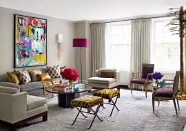 Na ścianie salonu obraz autorstwa Sally King Benedict, stolik kawowy marki Philip and Kelvin LaVerne, lampa podłogowa Karl Springer, stołki w stylu vintage marki Jansen tapetowane tkaniną marki Stark.