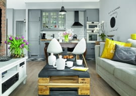 Europalety na salonach - stolik kawowy to dzieło Tomka, który po godzinach lubi poszaleć z młotkiem i wiertarką. Szafkę pod telewizor właściciele kupili w meblarnia.com.pl, kanapę w sklepie Inne Meble (stąd jest też zastawa).