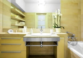 <B>Zwykle jest częścią szafki łazienkowej. Ostatnio projektanci coraz częściej rezygnują z szafek. Daje to więcej swobody w wyborze wielkości i kształtu blatu oraz materiału, z jakiego zostanie wykonany.</B> <BR >BLATY. Wysunięty i nieco obniżony granitowy blat z wpuszczoną umywalką to część większej konstrukcji, obłożonej gresem (tańszym od kamienia). Przód blatu zabezpieczono szeroką metalową listwą z relingiem na ręcznik.