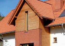 Przed zamontowaniem desek oblicówki, na styku elewacji klinkierowej i drewnianej należy zamontować listwę okapową, chroniącą przed zaciekaniem wody pod ocieplenie ze styropianu - może to być okapnik z blachy powlekanej lub pasek papy wywinięty na dekoracyjną deskę okapową.