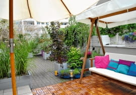 WIDOK TARASU Z KĄCIKA KAWOWEGO. Na pierwszym planie drewniana huśtawka, w głębi podniebna "plaża".