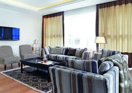 na biało. W oknach zasłony na podszewce, pod nimi rolety rzymskie z półprzejrzystej, białej tkaniny. Sofy Fama, fotele Antoinette, stół kawowy Franco, dywan Casablanca Terra (wszystkie przedmioty BBHome).